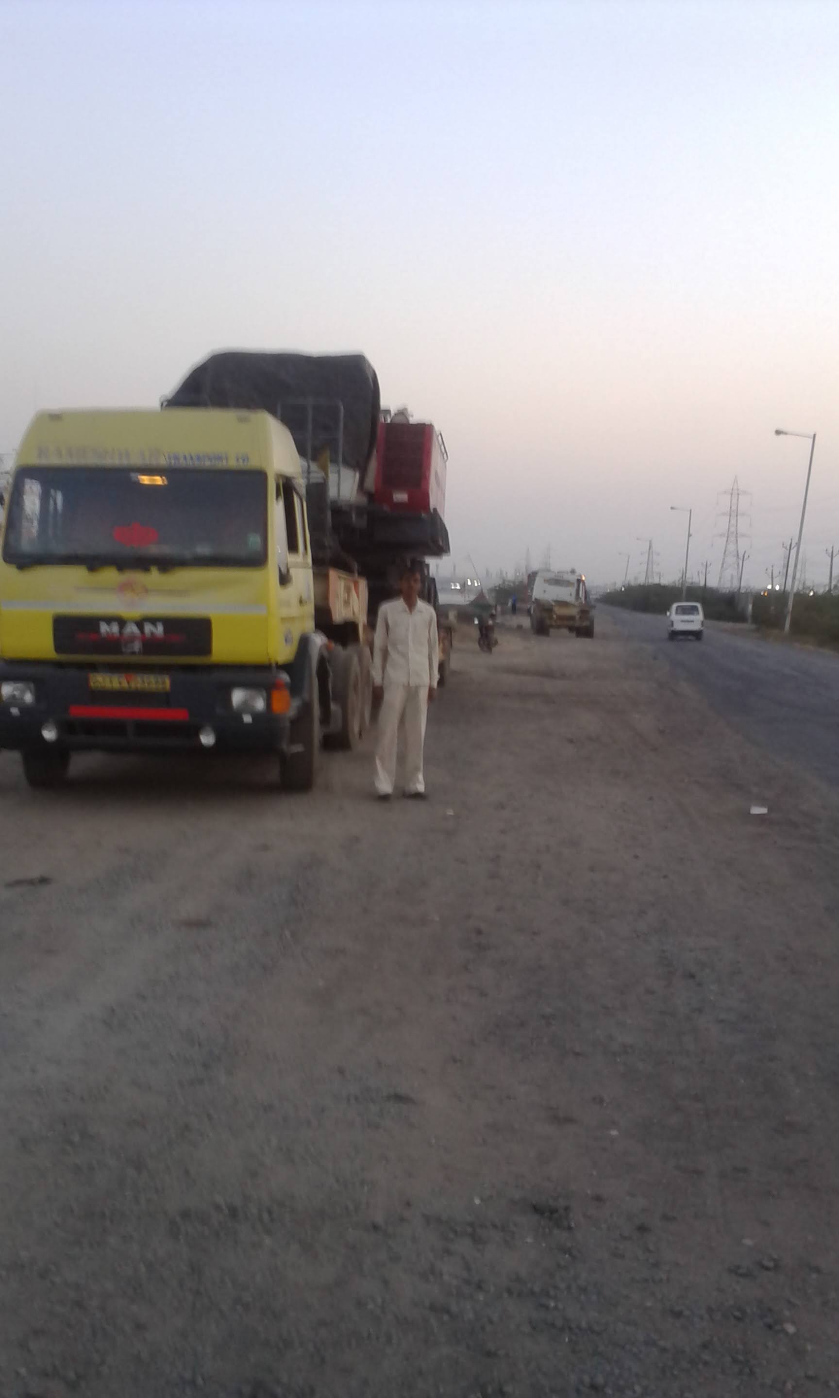 MJ Logistiks trailer moving heavy machinery on a highway